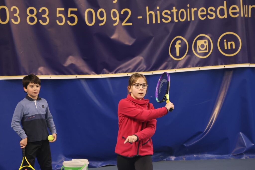 Une fille jouant au tennis pendant la formule Maxi Tennis VNTC