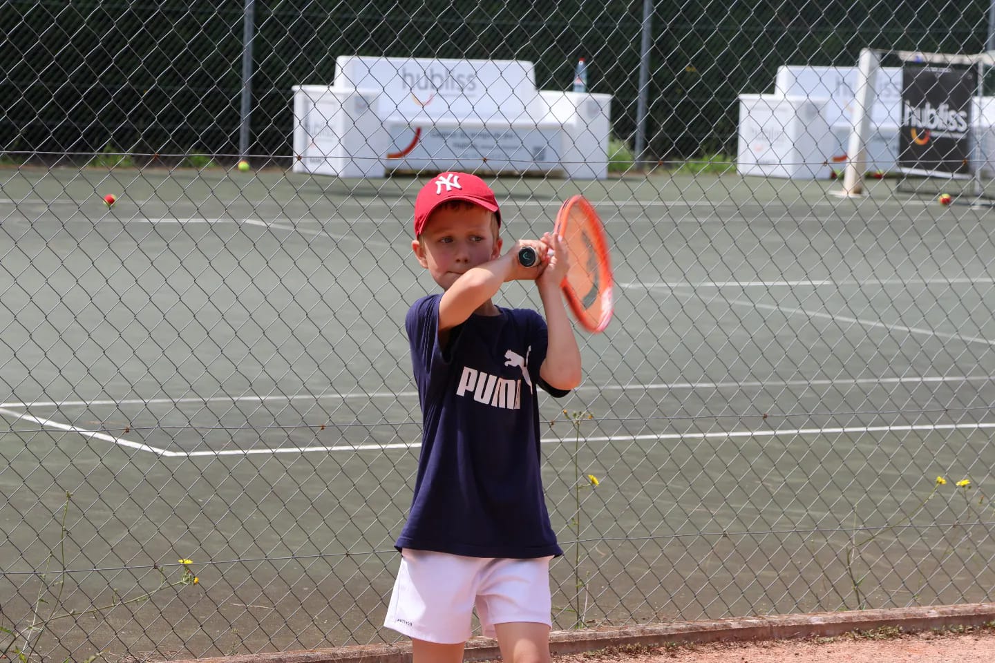 Un enfant jouant au tennis au club pendant le tennis périscolaire VNTC